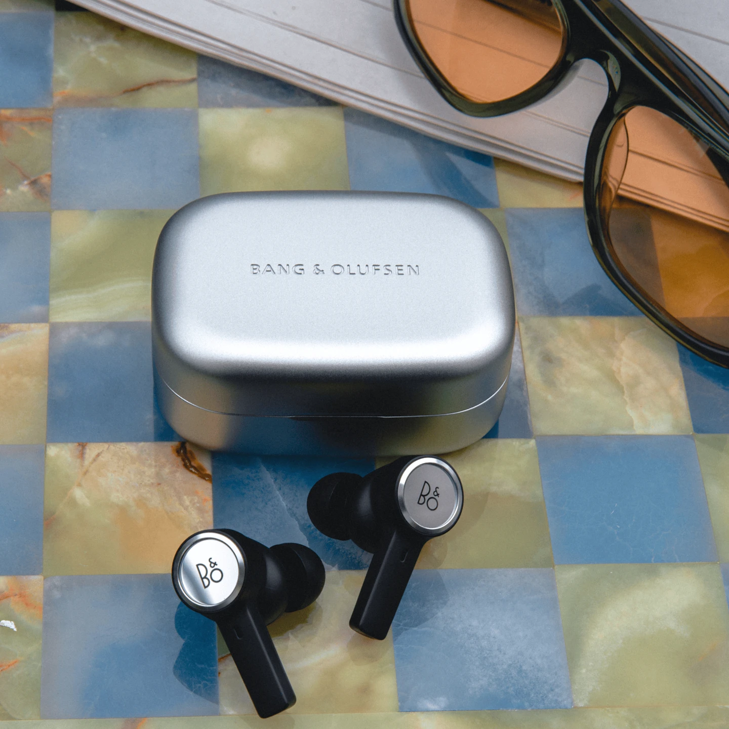 Beoplay Eleven shown in an open charging case
