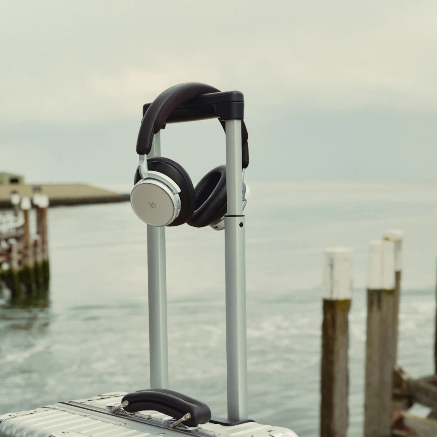 Suitcase with a pair of Beoplay H100 on the handle