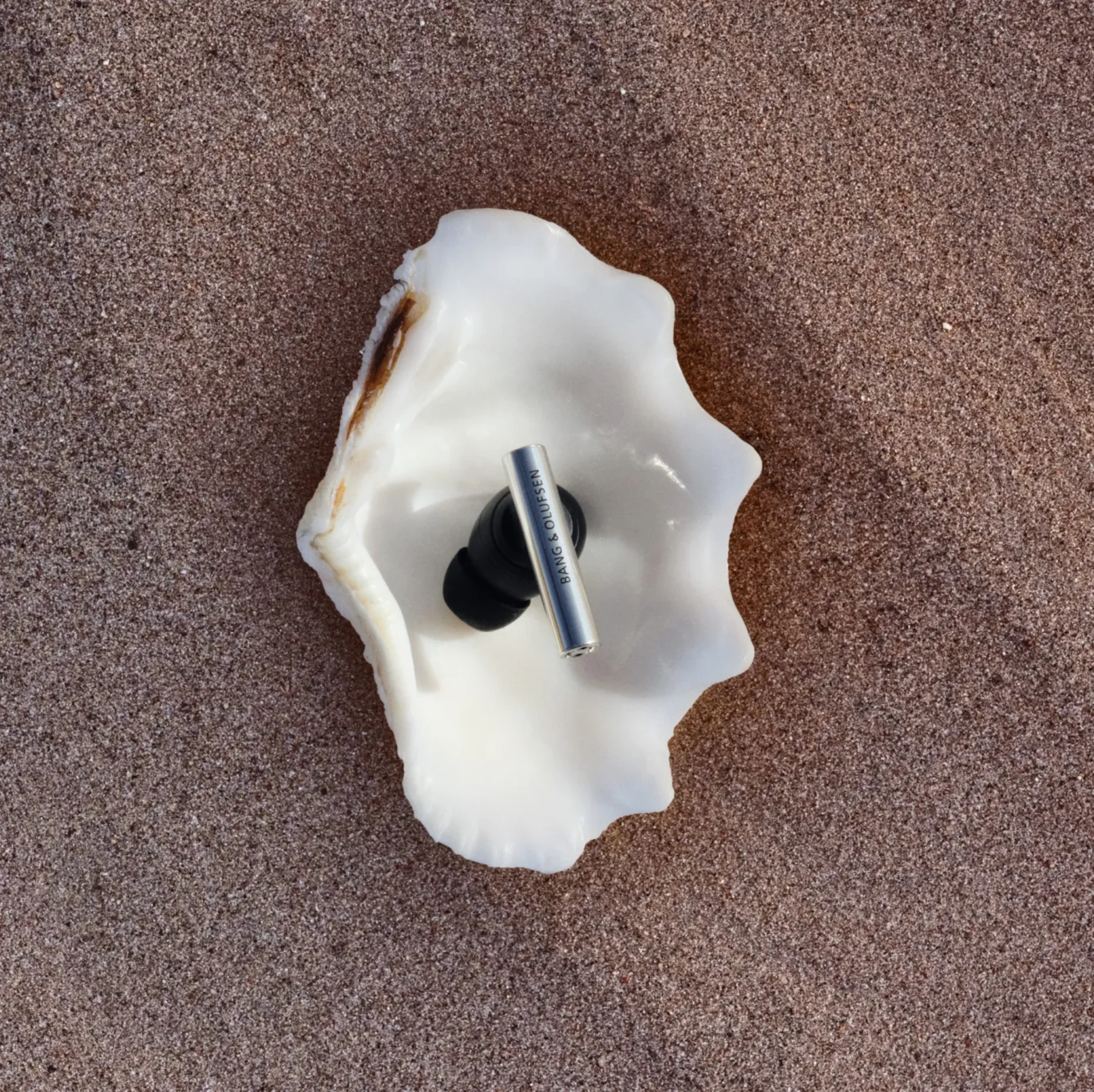 One of Beo Grace earphone placed on a sea shell