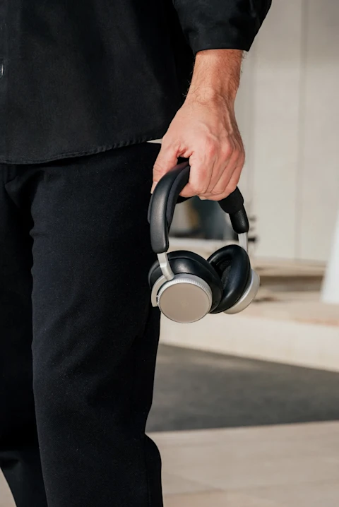 Fernando Alonso holding Bang & Olufsen Beoplay H100 headphones